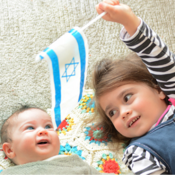 two girls lying on the floor with an Israeli flag