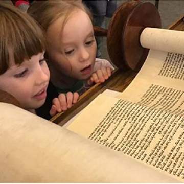 380 two little girls looking at the torah