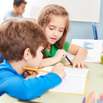 children writing in notebooks in class