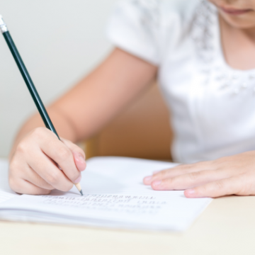 girl writing with a pencil and paper