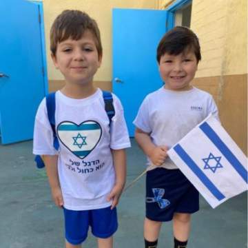 two young boys waving a Jewish flag