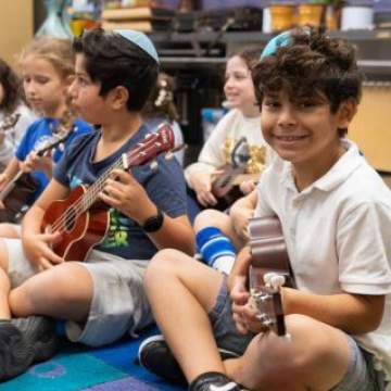 elementary school children playing guitar