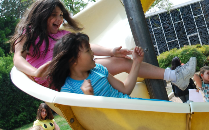 Two children going down a slide